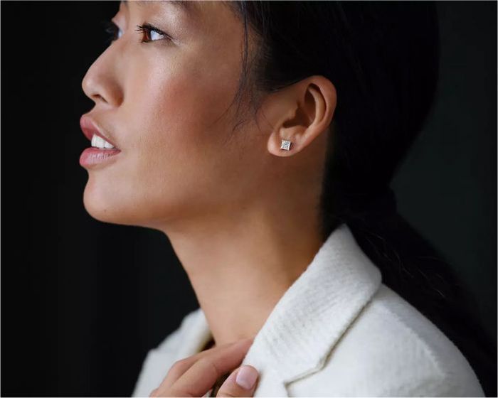 Asian female wearing white blazer and square diamond stud earrings